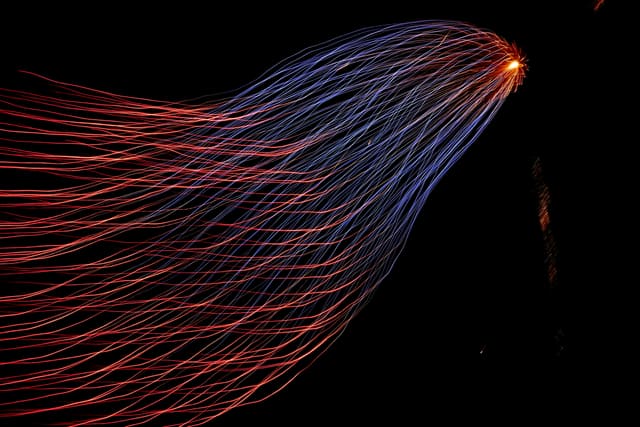 Long-exposure light trails streaming outward from a single bright point